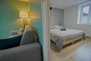 mała sypialnia z łóżkiem i kanapą w obiekcie Bel Appartement T2 40 M² w mieście Vaugneray