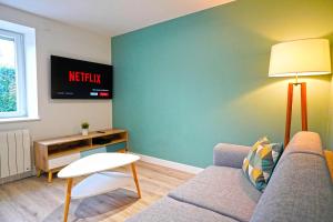 salon z kanapą i stołem w obiekcie Bel Appartement T2 40 M² w mieście Vaugneray
