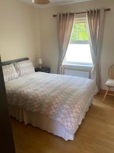 a bedroom with a large bed and a window at Glenrandel Valley in Claudy