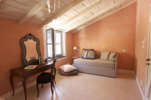 1 dormitorio con cama, escritorio y espejo en Casa Aquarela, en Cogorno
