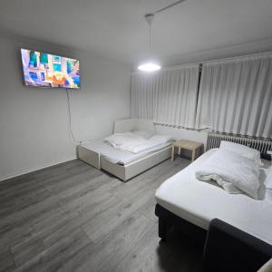 a room with two beds and a flat screen tv at Jagersborg alle nice Flat in Gentofte
