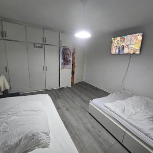 a bedroom with a bed and a tv on the wall at Jagersborg alle nice Flat in Gentofte +5 photos