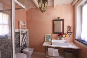 ein Badezimmer mit einem Waschbecken, einem WC und einem Spiegel in der Unterkunft Casa Aquarela in Cogorno