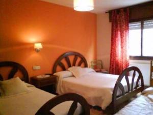 a hotel room with two beds and orange walls at Hostal Solpor in Vigo