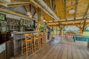 a bar with wooden stools in a restaurant at Siedlisko Nawiady - hotel butikowy in Nawiady