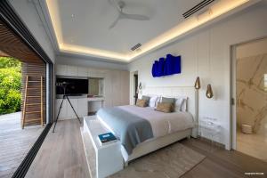 a bedroom with a bed and a television in it at Villa neuve à Lurin avec vue mer sunset à proximité de Gustavia in Gustavia +22 photos