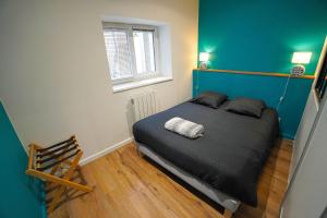 a bedroom with a bed with a blue wall at STUDIO RENOVE RDC TERRASSE + EXTERIEUR PAYSAGE in Grézieu-la-Varenne