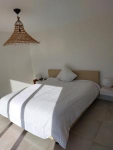a bedroom with a large white bed with a chandelier at Haut de Villa - Corsica in Lecci +45 photos