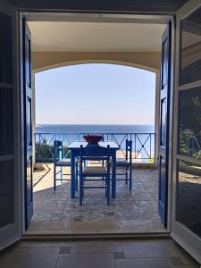 a dining room with a table and a view of the ocean at Villa Thea Kalymnos with swimming pool and sea view in Panormos Kalymnos
