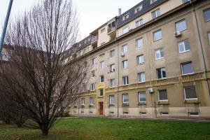 an apartment building with a tree in front of it at Spacious apartment with a fireplace in the city in Bratislava
