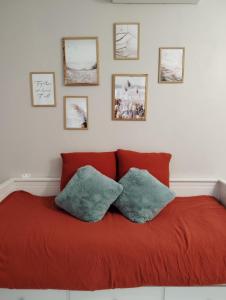 a red couch with two pillows in a room at le Studio charme et tranquillité in Plan-de-la-Tour