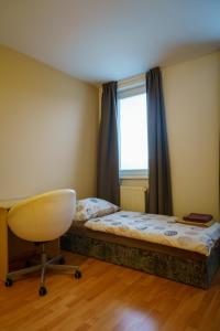 a bedroom with a bed and a desk and a window at Spacious apartment with a fireplace in the city in Bratislava