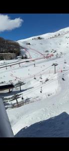 a snow covered ski slope with people skiing on it at Appartement Orcières-Merlette Pied des Pistes Piscine By Kelly in Orcières +4 photos