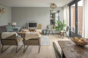 a living room with a couch and a table at Het Steven van Grou - luxury wellness house with hot tub in Grou