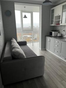 een woonkamer met een bank en een tafel bij Апартаменти Люкс 4 in Chmelnytsky