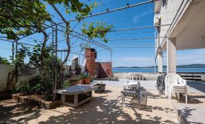 a patio with a table and chairs and the water at apartmani Nik in Bibinje