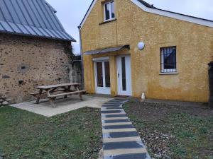 a picnic table and a bench in front of a building at maison au calme in Lanne