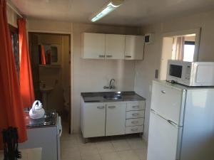 a kitchen with a white refrigerator and a microwave at The Shark in Punta Del Diablo