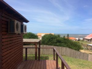 a deck with a view of the ocean from a house at The Shark in Punta Del Diablo