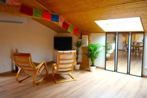 a room with two chairs and a flat screen tv at Eco-gîte Belle-étoile in Verrens-Arvey