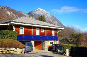 a house with cars parked in front of it with a mountain at Eco-gîte Belle-étoile in Verrens-Arvey