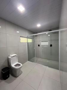 a bathroom with a toilet and a walk in shower at Oasis Chalés Camboriú in Camboriú +21 photos
