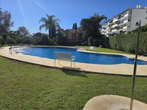a swimming pool with a bench in a park at Marbella city center appartment walking distance beach and plaza de los naranjos in Marbella