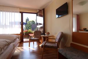 ein Hotelzimmer mit einem Bett, einem Tisch und Stühlen in der Unterkunft Gästehaus Schmid-Lopez in Bad Wildbad