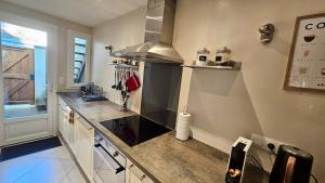 a kitchen with a counter and a stove top oven at Maison de bourg proche de la mer in Ouistreham