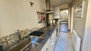 a kitchen with a sink and a counter top at Maison de bourg proche de la mer in Ouistreham