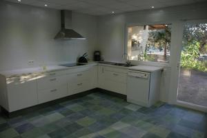 une cuisine avec des armoires blanches, un évier et une fenêtre dans l'établissement Casa Rural La Dehesa de Campoviejo, à Robledillo de Trujillo