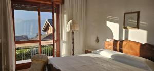 a bedroom with a bed and a large window at Casa Rosa in Cassina Valsassina