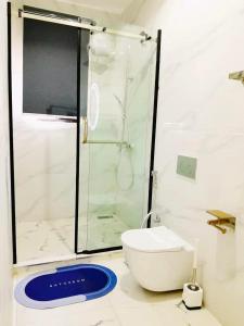 a bathroom with a toilet and a glass shower at Affordable and Comfortable Short-let Apartment in Lagos in Ikotun +7 photos