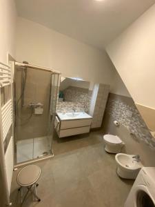 a bathroom with a shower and a toilet and a sink at Lux Appartamento in Busso +18 photos