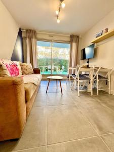 un salon avec un canapé et une table dans l'établissement LE BLUE PACIFIC- 150m de la plage- Terrasse- Wifi, à La Grande Motte