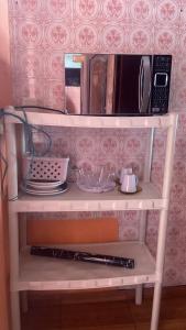 een witte plank met een magnetron en enkele borden bij Casa da Mãe Maria in Belém