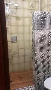 een badkamer met een douche en een witte tegelmuur bij Casa da Mãe Maria in Belém