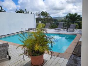 una piscina con sedie e un tavolo su una terrazza di Chez Karine & Harold a Sainte-Luce