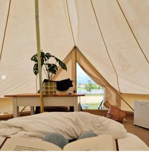 a person laying on a bed in a tent at Bergs Slussar Glamping in Vreta Kloster