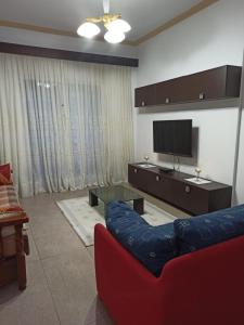 ヴロラにあるMarini's apartment , Vlorëのリビングルーム(赤いソファ、薄型テレビ付)