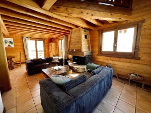a living room with a couch and a fireplace at Chalet Les Oursons in Bonnevaux
