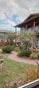 a house with a yard with plants in front of it at Wayak Flats PDR in Imbituba