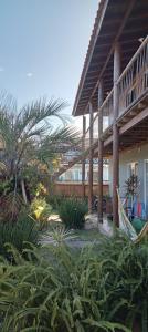 a patio of a house with palm trees and plants at Wayak Flats PDR in Imbituba