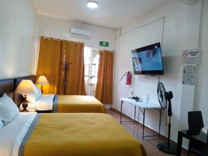a hotel room with two beds and a flat screen tv at Gran Tonantzin in San Martín de las Pirámides