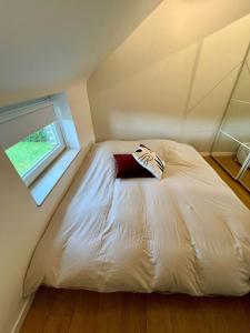 a bed in a small room with a window at Maison cosy dans le centre de Francorchamps in Stavelot
