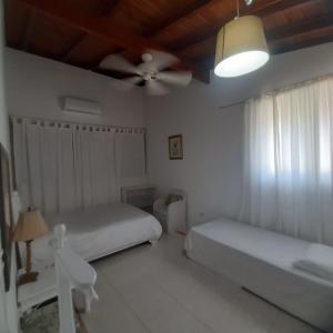 une chambre avec deux lits et un ventilateur de plafond dans l'établissement Villa Los Cerros, hermosa villa familiar, colina en el bosque y la playa, à La Pared 64 autres photos