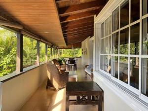 un porche grillagé avec une table et des chaises dans l'établissement Villa Los Cerros, hermosa villa familiar, colina en el bosque y la playa, à La Pared