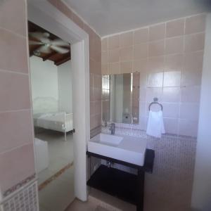 une salle de bain avec un lavabo, un miroir et un lit dans l'établissement Villa Los Cerros, hermosa villa familiar, colina en el bosque y la playa, à La Pared