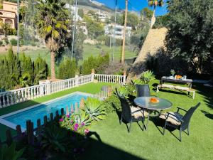 a backyard with a table and chairs and a pool at Spacious chalet on golf course in Altea