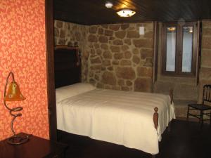 セロリコ・ダ・ベイラにあるCasa do Castelo de Celoricoの石壁のベッドルーム1室(ベッド1台付)